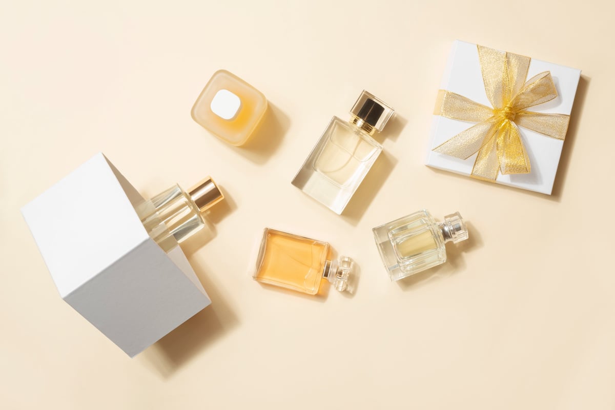 Collection of luxury perfume bottles and a gift box arranged on a beige surface